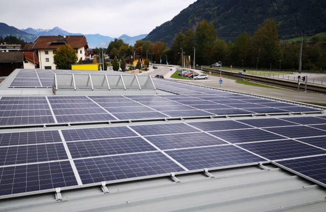 Photovoltaikanlage auf dem Dach der Kaltenbacher Zentrale mit Blick auf Berge und Ort